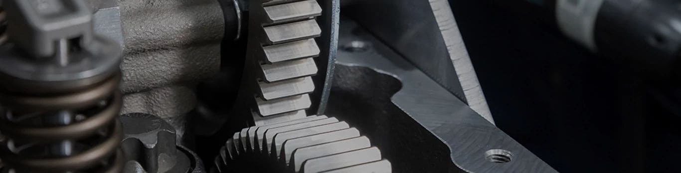 Close-up van in elkaar grijpende metalen tandwielen en veren in een mechanisch apparaat.