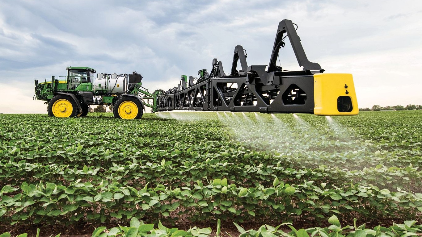 Close-up van een veldspuit van John Deere in een open veld.