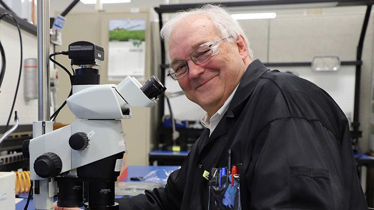 Dr. William F. Cooper achter een microscoop