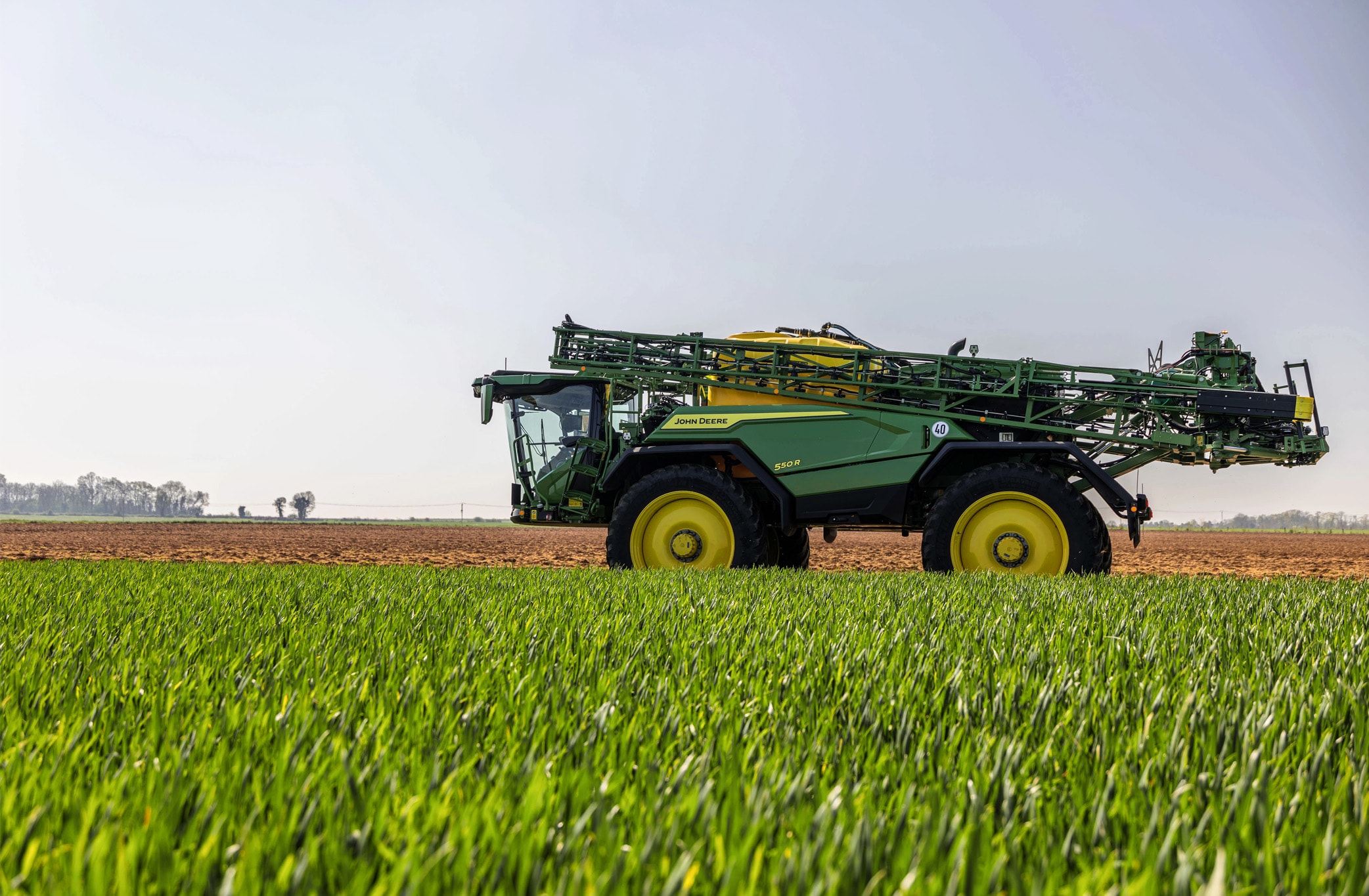 Zijaanzicht van een 500R-veldspuit die in een veld werkt