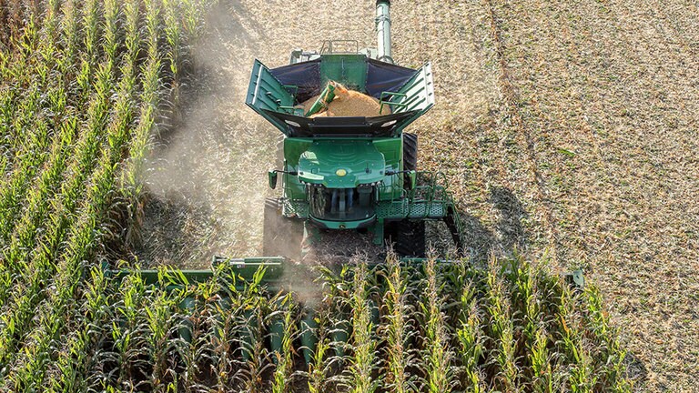 Een John Deere X-reeks maaidorser die ma&iuml;s oogst