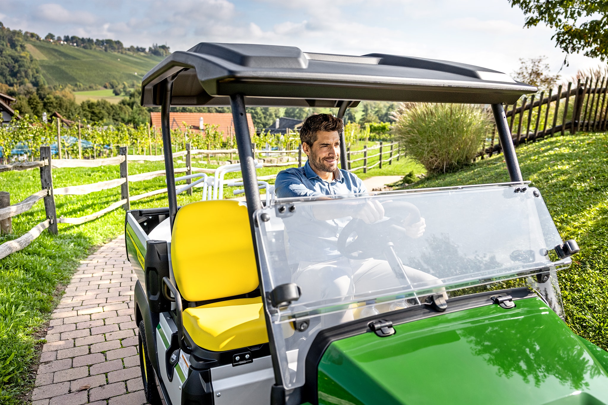 Close-up van John Deere Gator GS-interieur met gele stoelen en stuurwiel